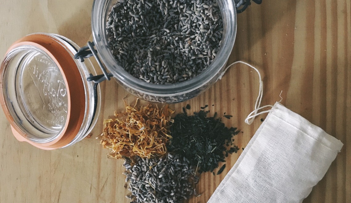 Ingredients for an herbal tea bath. Dried lavender, calendula and green tea on wood cutting board