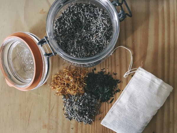 Ingredients for an herbal tea bath. Dried lavender, calendula and green tea on wood cutting board