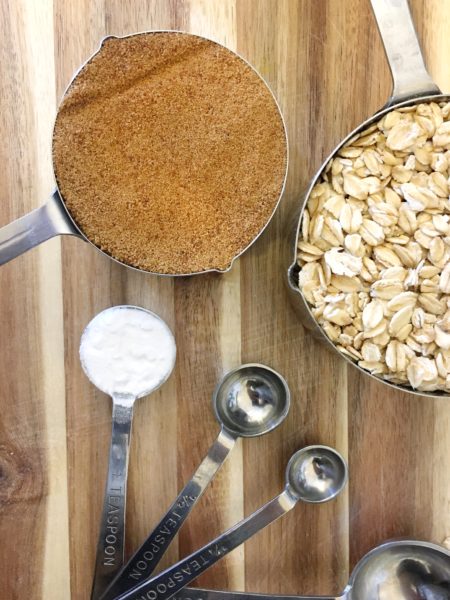 Measuring cups of coconut sugar, gluten-free oats and baking soda